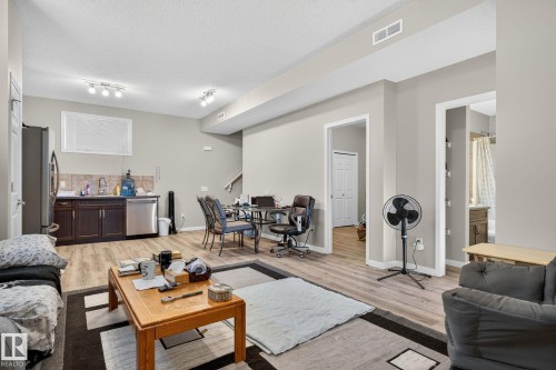 Living room featuring light wood-style flooring, stairs, and a textured ceiling - 196, 142 Selkirk Place, Leduc, AB - Indoor Photo Showing Living Room
