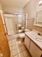 Bathroom with vanity, enclosed tub / shower combo, and light flooring - 
