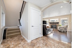 Stairs with a textured ceiling, a fireplace, arched walkways, and tile patterned floors - 