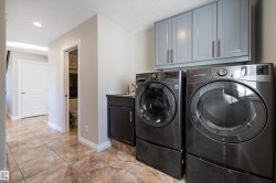 Laundry area with washing machine and clothes dryer, recessed lighting, and cabinet space - 