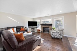Living room featuring a fireplace, a textured ceiling, hardwood / wood-style floors, and recessed lighting - 