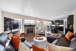 Living room featuring recessed lighting, dark wood-type flooring, a textured ceiling, and a fireplace - 