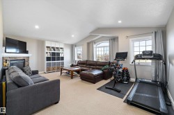 Exercise area with light carpet, lofted ceiling, a fireplace, recessed lighting, and a textured ceiling - 