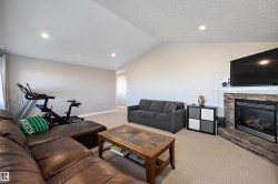Living room with lofted ceiling, carpet, a fireplace, recessed lighting, and a textured ceiling - 