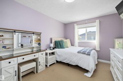 Bedroom featuring light colored carpet and a textured ceiling - 