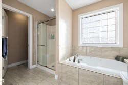 Full bath featuring a stall shower, a garden tub, and light tile patterned flooring - 