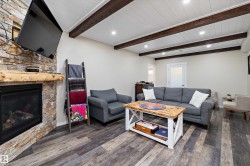 Living area with recessed lighting, dark wood-style floors, and a fireplace - 