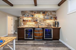 Indoor bar with open shelves, wine cooler, dark wood-style flooring, and beam ceiling - 