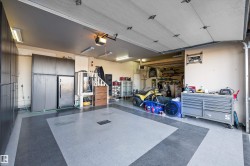 Garage featuring a workshop area, a garage door opener, and a heating unit - 