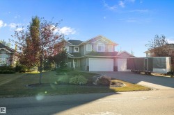 View of front of property with driveway, a front lawn, and a garage - 