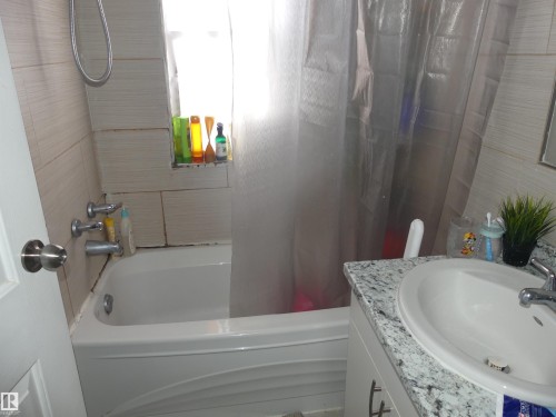 Bathroom featuring vanity and shower / bath combination with curtain - 10618 96 Street Nw, Edmonton, AB - Indoor Photo Showing Bathroom