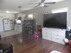 Living area featuring healthy amount of natural light, dark wood-style flooring, and a ceiling fan - 