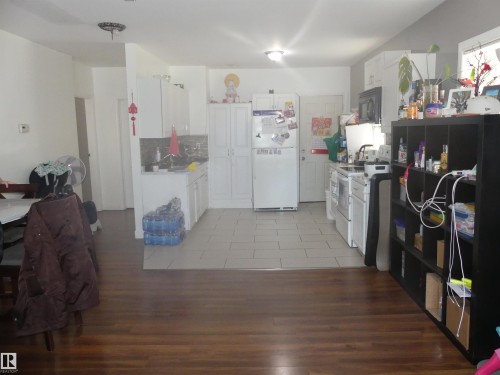 Kitchen with light countertops, white appliances, white cabinetry, and tasteful backsplash - 10618 96 Street Nw, Edmonton, AB - Indoor Photo Showing Kitchen