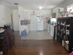Kitchen with light countertops, white appliances, white cabinetry, and tasteful backsplash - 