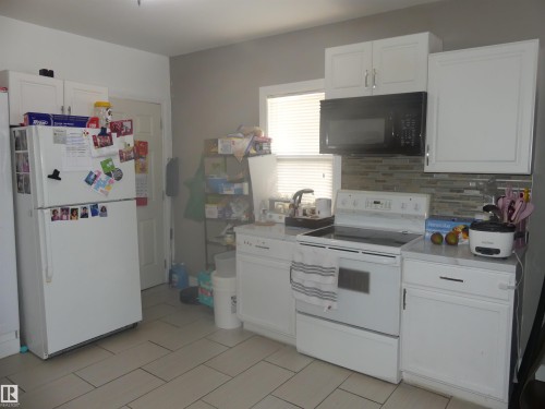 Kitchen featuring white appliances, light countertops, white cabinets, and tasteful backsplash - 10618 96 Street Nw, Edmonton, AB - Indoor Photo Showing Kitchen