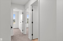 Corridor featuring light carpet and baseboards - 