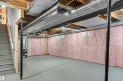 Unfinished below grade area featuring stairway and heating unit - 