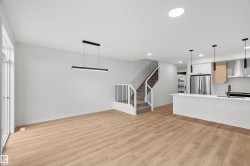 Unfurnished living room featuring light wood-type flooring, stairway, and recessed lighting - 