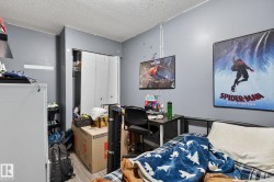 Bedroom with a textured ceiling, wood finished floors, and a closet - 
