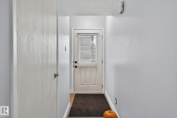 Doorway with a textured ceiling and baseboards - 