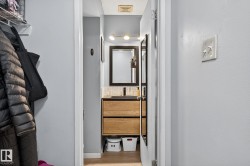 Hallway with light wood-type flooring and a sink - 