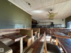 Dining space with dark wood-style flooring, wood ceiling, and ceiling fan - 