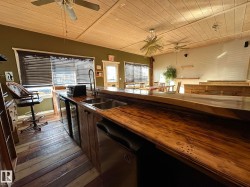 Kitchen featuring wood ceiling, wooden counters, a ceiling fan, and dishwasher - 
