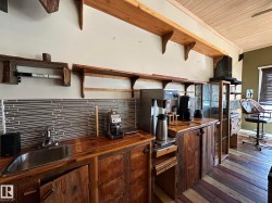 Kitchen with wood counters, a wood ceiling with exposed beams, backsplash, dark wood-type flooring, and open shelves - 
