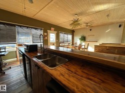 Kitchen with ceiling fan, wooden ceiling, butcher block counters, and dishwasher - 