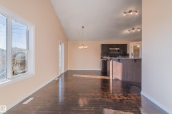 Unfurnished living room with a chandelier, lofted ceiling, and dark wood finished floors - 