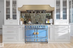 Bar area with glass insert cabinets, white cabinets, and premium range hood - 