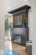 Detailed view of a glass covered fireplace, wood finished floors, and recessed lighting - 