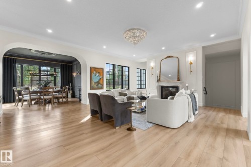 Living area with a chandelier, crown molding, a premium fireplace, arched walkways, and recessed lighting - 183 Windermere Drive, Edmonton, AB - Indoor Photo Showing Living Room