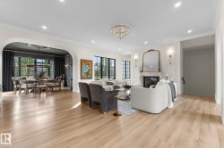 Living area with a chandelier, crown molding, a premium fireplace, arched walkways, and recessed lighting - 