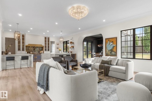 Living area with a chandelier, crown molding, arched walkways, recessed lighting, and light wood-style flooring - 183 Windermere Drive, Edmonton, AB - Indoor Photo Showing Living Room