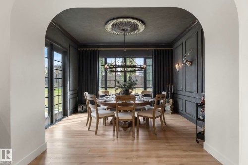 Dining area featuring arched walkways, crown molding, light wood finished floors, and a chandelier - 183 Windermere Drive, Edmonton, AB - Indoor Photo Showing Dining Room