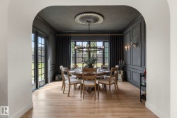 Dining area featuring arched walkways, crown molding, light wood finished floors, and a chandelier - 
