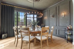 Dining area featuring a decorative wall, a chandelier, wood finished floors, and crown molding - 
