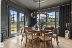 Dining room featuring wood finished floors, crown molding, and a chandelier - 