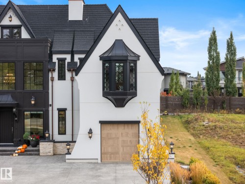 View of front facade with stucco siding, a garage, concrete driveway, and a chimney - 183 Windermere Drive, Edmonton, AB - Outdoor