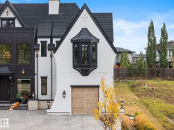View of front facade with stucco siding, a garage, concrete driveway, and a chimney - 