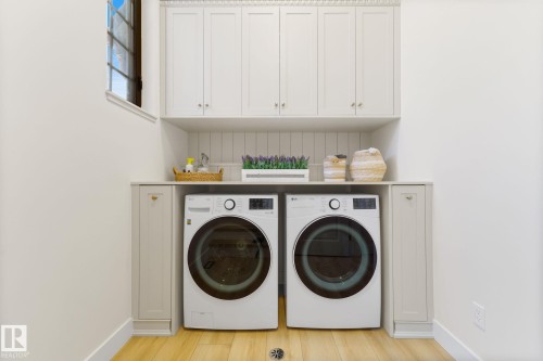 Laundry area featuring separate washer and dryer, light wood-style floors, and cabinet space - 183 Windermere Drive, Edmonton, AB - Indoor Photo Showing Laundry Room
