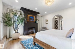 Bedroom with arched walkways, hardwood / wood-style flooring, a fireplace, and recessed lighting - 