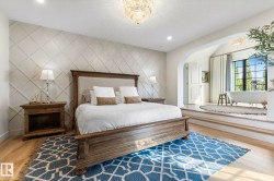 Bedroom with a chandelier, wood finished floors, an accent wall, recessed lighting, and arched walkways - 
