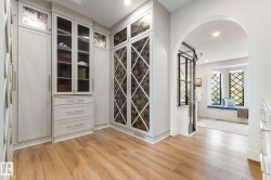 Wine area with light wood-type flooring, recessed lighting, and arched walkways - 
