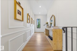 Hall with light wood-style floors, recessed lighting, and a decorative wall - 