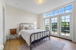 Bedroom with multiple windows, access to outside, light wood-style floors, and a water view - 