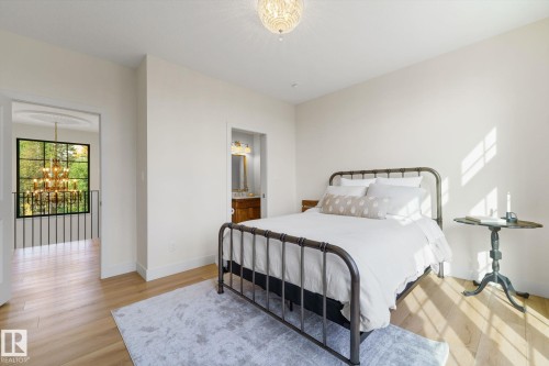 Bedroom featuring a chandelier, light wood finished floors, and ensuite bath - 183 Windermere Drive, Edmonton, AB - Indoor Photo Showing Bedroom