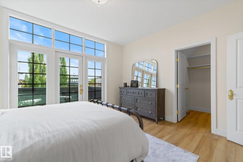 Bedroom featuring a spacious closet, light wood-style floors, and access to outside - 183 Windermere Drive, Edmonton, AB - Indoor Photo Showing Bedroom