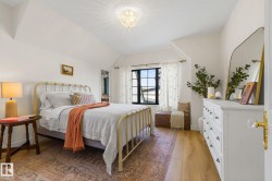 Bedroom featuring light wood-type flooring, vaulted ceiling, and a chandelier - 